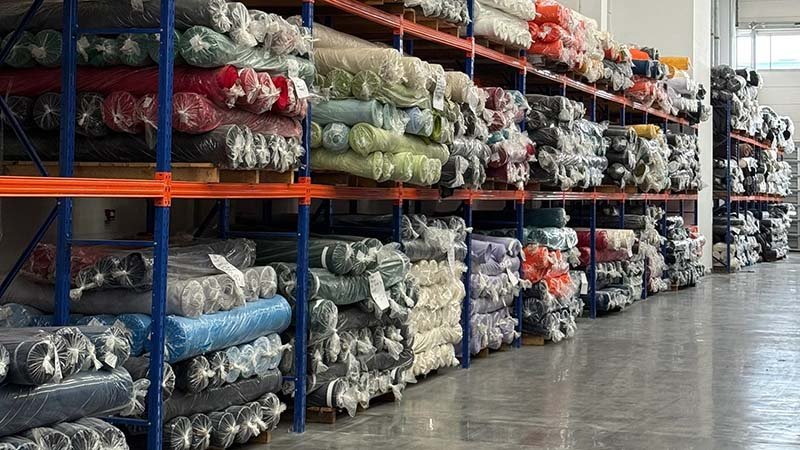 a large roll of fabric being loaded onto an industrial machine