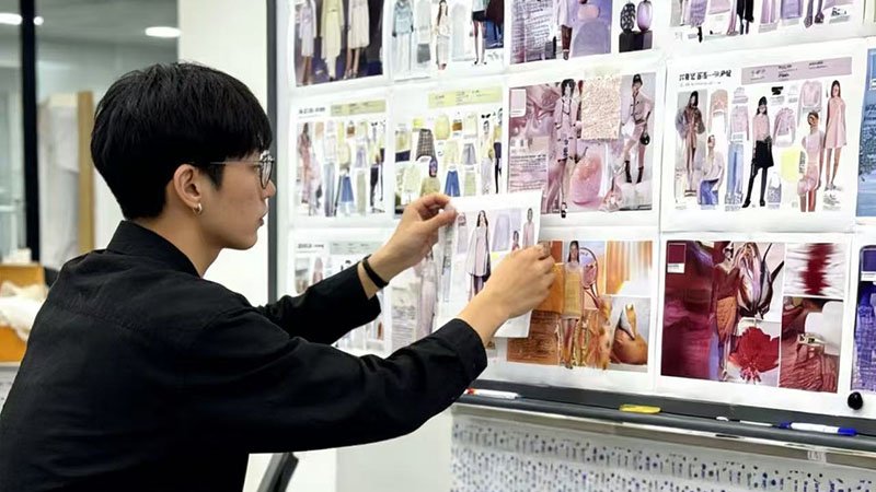 Strategically Planning Your First Production Batch a designer pointing to a single "hero" product on a design board filled with ideas