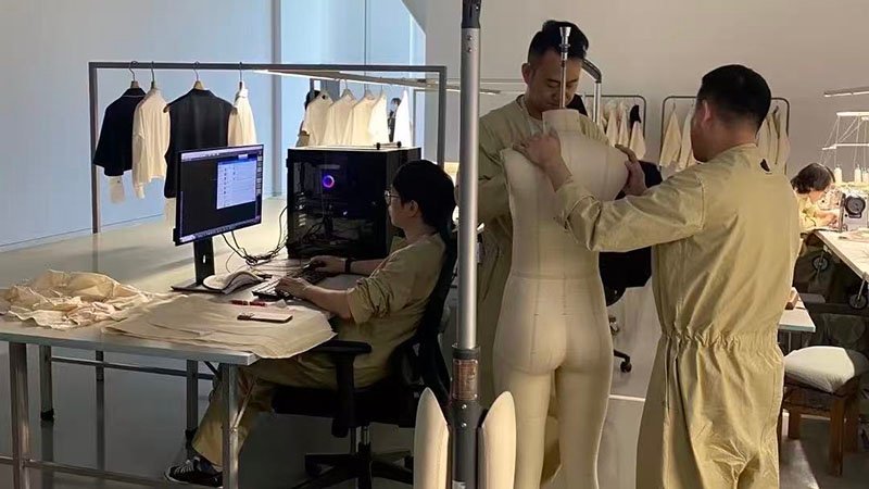 The Apparel Sampling and Fit Testing Stage a clothing technician fitting a prototype sample on a fit model and making adjustments